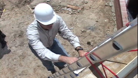 Screen shot of video with a man climbing a ladder