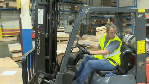 Screen shot of video with woman in forklift looking back over left shoulder