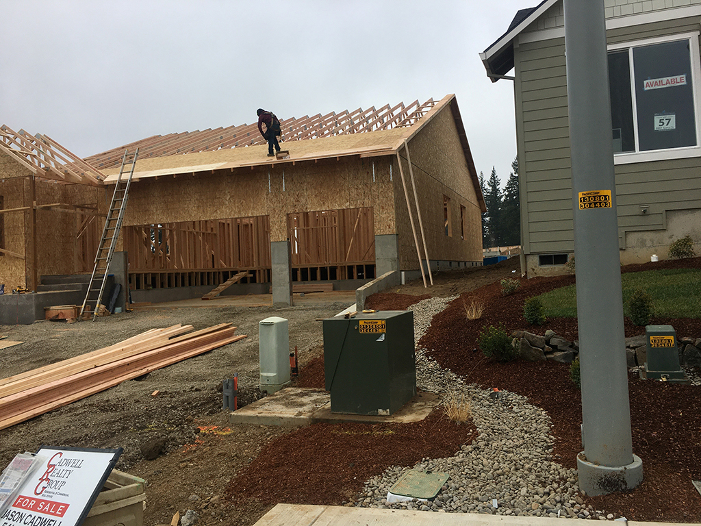 At a construction site in Aumsville, a worker is on a roof with no fall protection